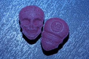 Pink skull ecstasy pill close up background high quality print purple army dope narcotics substance high dose psychedelic way of life photo