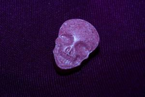 Pink skull ecstasy pill close up background high quality print purple army dope narcotics substance high dose psychedelic way of life photo