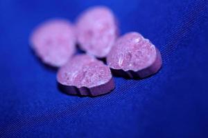 Pink skull ecstasy pill close up background high quality print purple army dope narcotics substance high dose psychedelic way of life photo