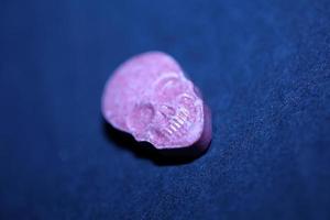 Pink skull ecstasy pill close up background high quality print purple army dope narcotics substance high dose psychedelic way of life photo
