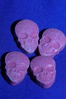 Pink skull ecstasy pill close up background high quality print purple army dope narcotics substance high dose psychedelic way of life photo