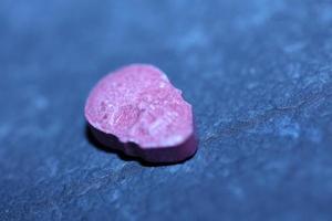 Pink skull ecstasy pill close up background high quality print purple army dope narcotics substance high dose psychedelic way of life photo