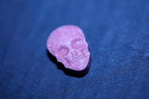 Pink skull ecstasy pill close up background high quality print purple army dope narcotics substance high dose psychedelic way of life photo