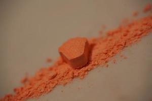 Orange pills with mdma ecstasy dope rolex drug close up background fine art in high quality print photo