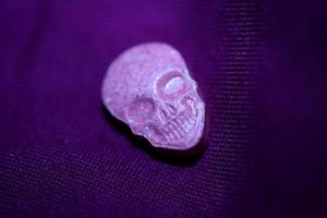 Pink skull ecstasy pill close up background high quality print purple army dope narcotics substance high dose psychedelic way of life photo