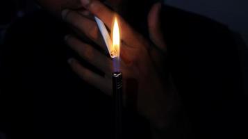 Smoker Lighting a Cigarette with a Gas Lighter. photo