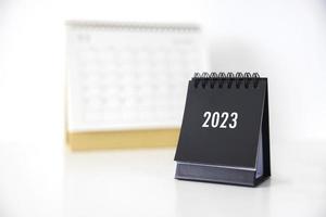 Calendario comercial 2023 en la mesa de la oficina en el día de año nuevo. hacer un plan de trabajo para el inicio del año. concepto sobre celebración, negocios, navidad, año nuevo. foto