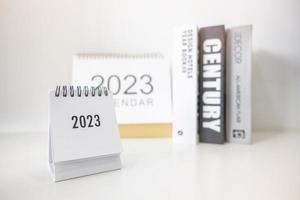 Calendario comercial 2023 en la mesa de la oficina en el día de año nuevo. hacer un plan de trabajo para el inicio del año. concepto sobre celebración, negocios, navidad, año nuevo. foto