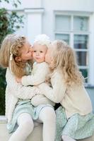 3 niñas de pelo claro se abrazan. amor de hermanas foto