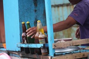 an Indonesian penjual mie ayam bakso or meatball chicken noodle seller who is making chicken noodles for the buyer. photo