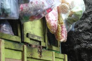 a vegetable seller whose cart is filled with various crackers on the side of the road in a housing complex. photo