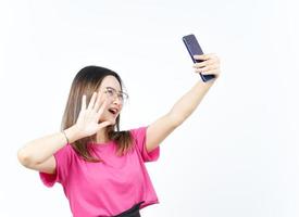 tómate un selfie usando un smartphone de una hermosa mujer asiática aislada de fondo blanco foto