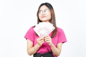 sosteniendo un nuevo billete de 100.000 rupias indonesias de una hermosa mujer asiática aislada de fondo blanco foto