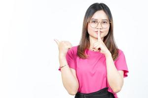 Shh gesture, Presenting and Pointing Side Product Using Thumb Of Beautiful Asian Woman photo