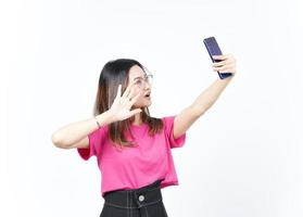 tómate un selfie usando un smartphone de una hermosa mujer asiática aislada de fondo blanco foto