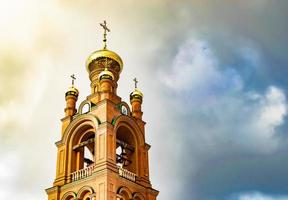 Cruz de la iglesia cristiana en alta torre campanario para la oración foto