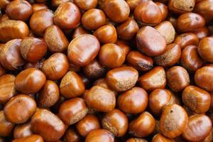 Top view heap of chestnuts. Pile of ripe chestnuts for food background. photo