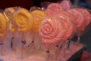 Various colored candies and sweets for sale placed in trays, available at flea market. photo