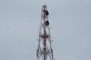 telephone transmission tower There is a signal dish on the pole. photo