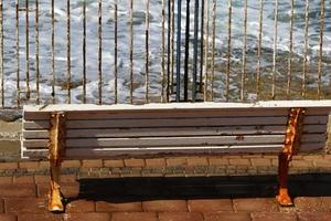Bench for rest in the city park on the seashore. photo