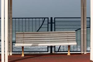 Bench for rest in the city park on the seashore. photo
