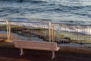 Bench for rest in the city park on the seashore. photo