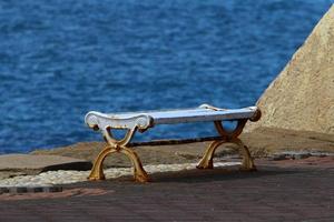 Bench for rest in the city park on the seashore. photo