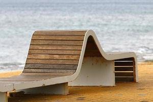 Bench for rest in the city park on the seashore. photo