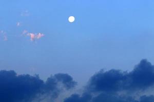 Moon and clouds in the sky over the sea photo