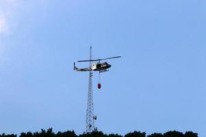 un helicóptero apaga un incendio forestal en las montañas del norte de israel. foto