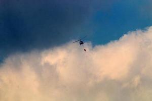 un helicóptero apaga un incendio forestal en las montañas del norte de israel. foto
