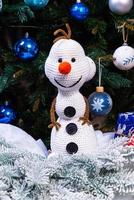 Knitted snowmen in colorful hats and scarves on a blue background. The concept of Christmas, New Year and winter fairy tale. photo