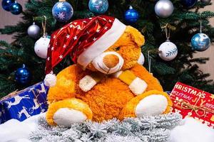 Toy bear wishes you a Merry Christmas. New Year. Christmas decorations, toys, gifts. Souvenirs for the new year. Christmas decoration. Garland. Christmas symbol. Santa Claus,