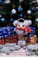 suave peluche de búho con auriculares y bufanda de punto. regalo de invierno para niños. divertido búho de juguete rojo y blanco de punto con un sombrero rojo y ojos grandes foto