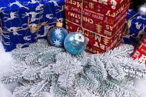 pasatiempo creativo de manualidades. hacer bolas y adornos navideños artesanales hechos a mano con abeto de fieltro. árbol de navidad con bolas de colores y cajas de regalo sobre una pared de ladrillo blanco con bolas azules y blancas foto