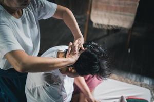Massage and spa relaxing treatment of office syndrome traditional thai massage style. Asain senior female masseuse doing massage treat head, back pain, arm pain, foot and stress for old woman tired. photo