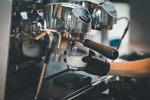 Barista cafe making coffee preparation service concept in restaurant. Close up hand barista making fresh coffee with coffee machine in the cafe. Making fresh coffee espresso. photo