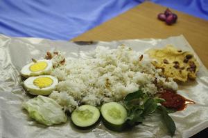 Nasi uduk or steamed rice cooked with eggs and vegetables photo