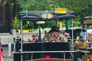 Yogyakarta, Indonesia on October 2022. Rear view of a wagon or Andong driver on Jalan Malioboro, Yogyakarta. photo