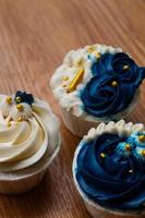 Luxurious and elegant cupcakes, with white cream and navy blue with gold sprinkles. photo