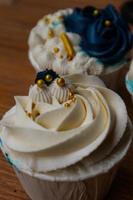 Luxurious and elegant cupcakes, with white cream and navy blue with gold sprinkles. photo