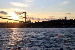 viajar a estambul, turquía. la puesta de sol en el bósforo con vistas al puente. foto