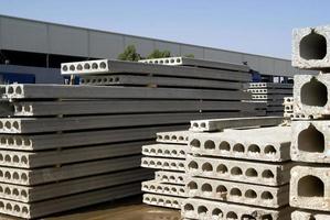 Stack of precast reinforced concrete slabs in a house-building factory workshop photo