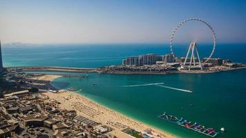 Dubai, Emiratos Árabes Unidos el 27.05.2021. arenas de playa marina jbr y olas meraas isla de aguas azules y una noria gigante durante la puesta de sol. el mejor destino turístico en emiratos árabes unidos. foto