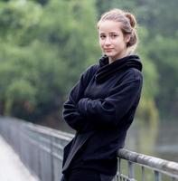 Portrait of young girl smiling. Beautiful woman standing one person outdoor. A cheerful, long brunette-haired, brown eyes female has a positive emotion freedom of leisure activity in a natural park. photo