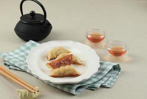 gyoza japonesa o bocadillo de albóndigas servido con té foto