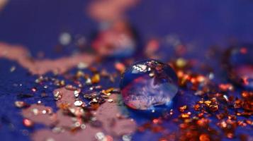 Close-up Of water drop with glitter on it in different colorful loghts in Karachi Pakistan 2022 photo