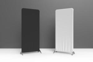 A black and white vertical cloth display stand standing on a white surface in front of a grey wall. 3D rendered illustration for mockup and graphic resources. photo