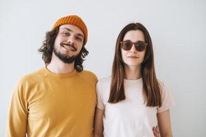 Portrait of smiling couple young family hipsters against gray wall photo