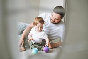 Happy father young man and baby girl little daughter having fun playing with toy in children room at home, selective focus photo